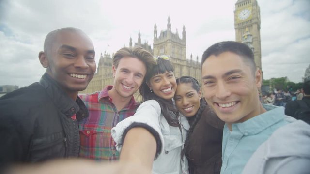  Happy mixed ethnicity friends outdoors in the city pose to take a selfie