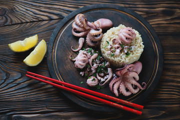 Pickled octopuses with brown rice in a rustic wooden setting