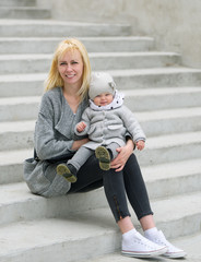 Mother and her daughter sit on steps.