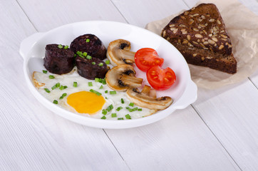 fried egg with mushrooms, tomatoes and black pudding
