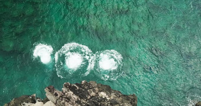Aerial view cliff jumping into ocean, summer lifestyle fun