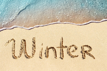 Word Winter handwritten on sand