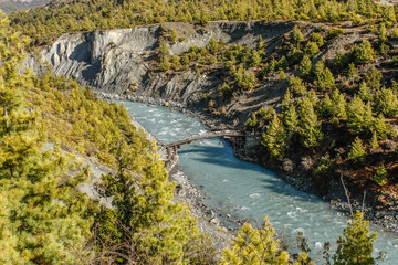 Beautiful view from top of mountains at river valley with wooden hunchbacked bridge