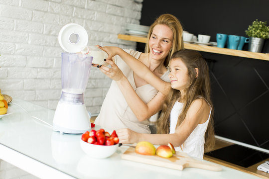 Mother and daughter blending smoothie