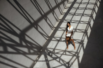 raven haired indian lady posing in geometrical shadows of metal stractures