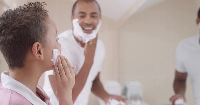 Happy smiling father and son spending time together and shaving