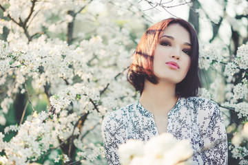 Beautiful young woman in blooming sakura - 110638679