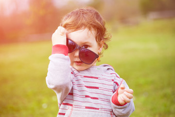 Little boy tries on his mother's glasses.