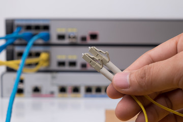 hand  holding optic fiber cables with connectors