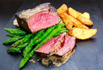 Beef steak Mignon cooked with Asparagus, potatoes, garlic and tomatoes. 