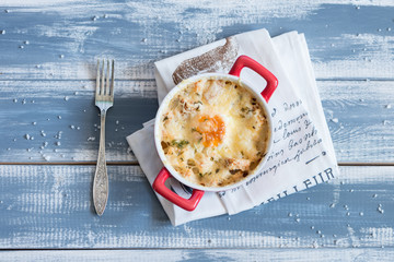 Fried eggs in red plates at wooden background