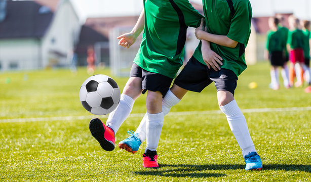 Young boy soccer players kicking ball