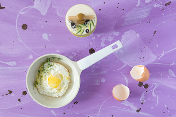 Fried eggs at lilac background