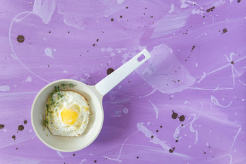 Fried eggs at lilac background