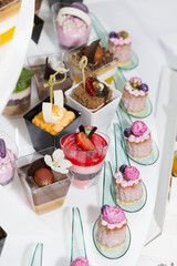 mini canapes in plastic cups decorated with edible flowers