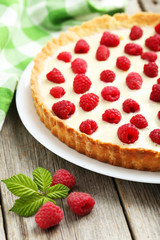 Sweet tart cake with raspberries on grey wooden background