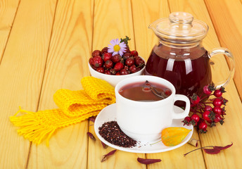 Jug and cup  rosehip drink on light wood background