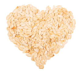 The shape of a heart lined with pumpkin seed isolated on white
