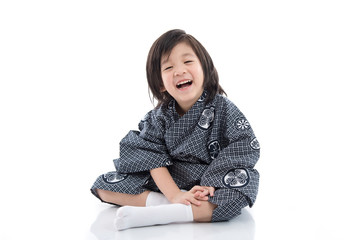 Happy asian boy in kimono sitting