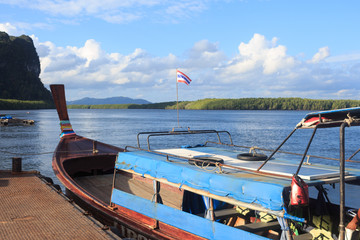 Fototapeta na wymiar wooden passenger boat park at the jetty in blue sky sea