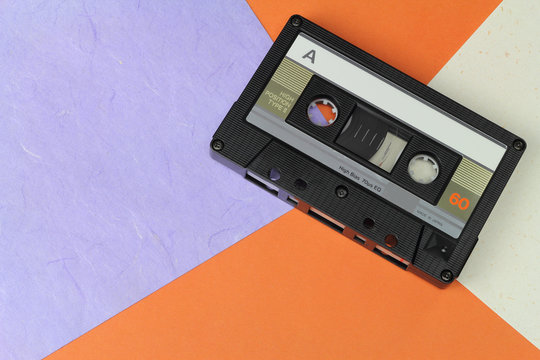 Audio Compact Cassette C60 tape with a blank label on a colored background