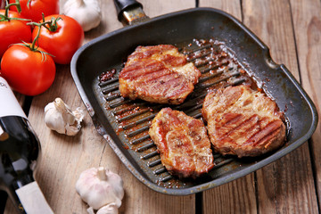 Roasted beef fillet on pan, on wooden background