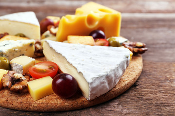 Different kinds of cheese on wooden background