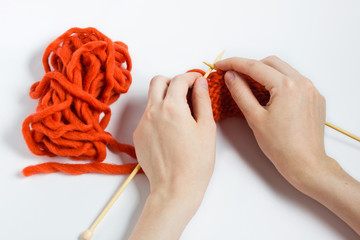 Women's hands with knitting needles.