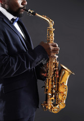 Naklejka na ściany i meble African American jazz musician playing the saxophone, closeup