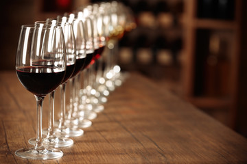 Many glasses of different wine in a row on bar counter