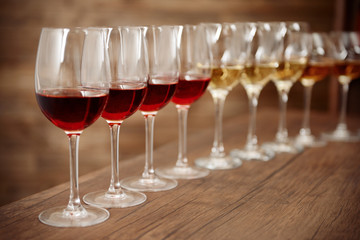 Many glasses of different wine in a row on bar counter