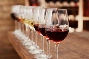 Many glasses of different wine in a row on bar counter