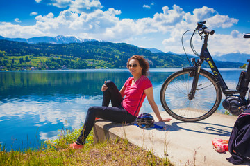 woman with e-bike enjoying view over lake-lake and bike 04