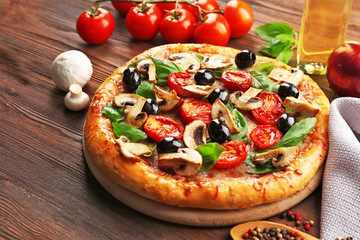 Delicious tasty pizza with ingredients on wooden table