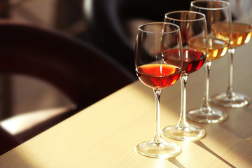 Many glasses of different wine in a row on a table