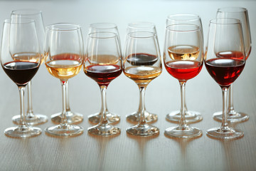 Many glasses of different wine in a row on a table