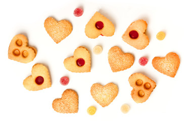 Heart-shaped tea cookies and gum drops on white background