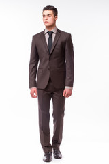 Handsome young businessman  with luck in suit standing against white background