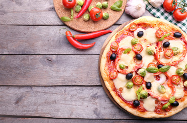 Delicious pizza with cheese and vegetables on wooden background