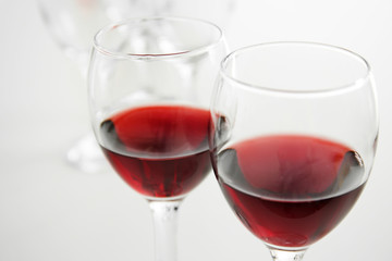 Glasses of red wine on white table closeup
