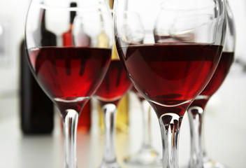 Glasses of red wine on white table closeup
