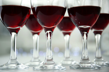 Glasses of red wine on white table closeup