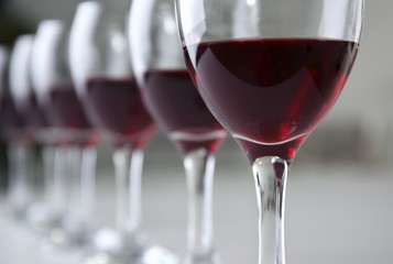 Glasses of red wine on white table closeup