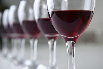 Fotobehang Glasses of red wine on white table closeup © Africa Studio