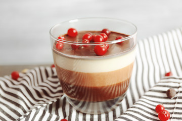 Delicious dessert with rowan in glass on table