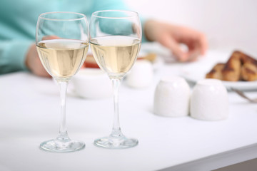 Dinner with glasses of wine on light blurred background