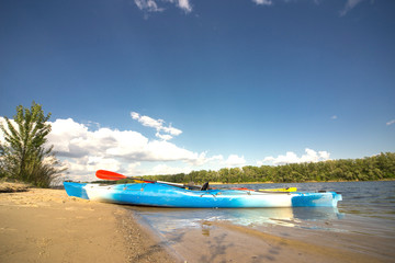 Camping with kayaks on the beach on a sunny day.