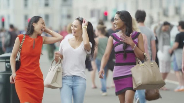  Attractive female friends chatting together outdoors in the city