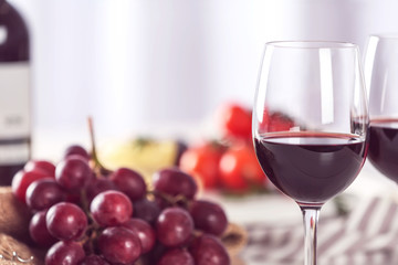 Glasses of red wine with food on blurred background