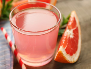 Ripe grapefruits and fresh juice with mint, close up